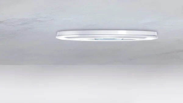 Das Bild zeigt einen weißen, an der Decke befestigten FLAT Präsenz- und Bewegungsmelder von der Seite