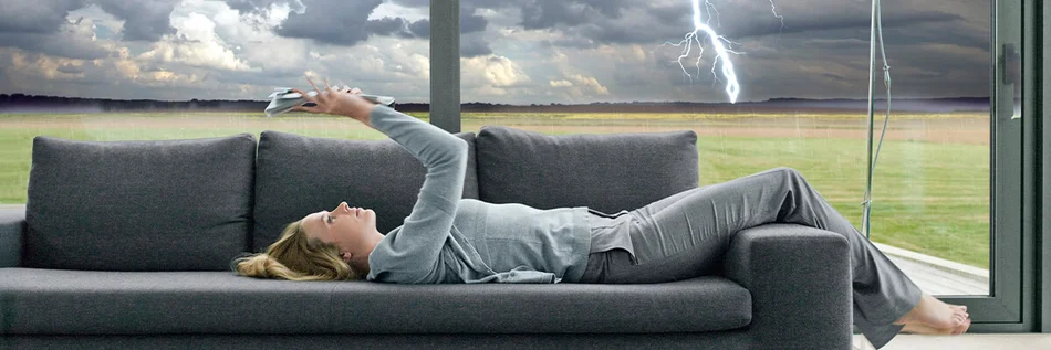 Das Bild zeigt eine Person, die auf einem Sofa liegt und eine Zeitschrift liegt.