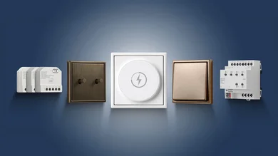 Das Bild zeigt verschiedene moderne Schalter, Taster und Steuerungsmodule für die Elektroinstallation, stilvoll vor blauem Hintergrund angeordnet.
