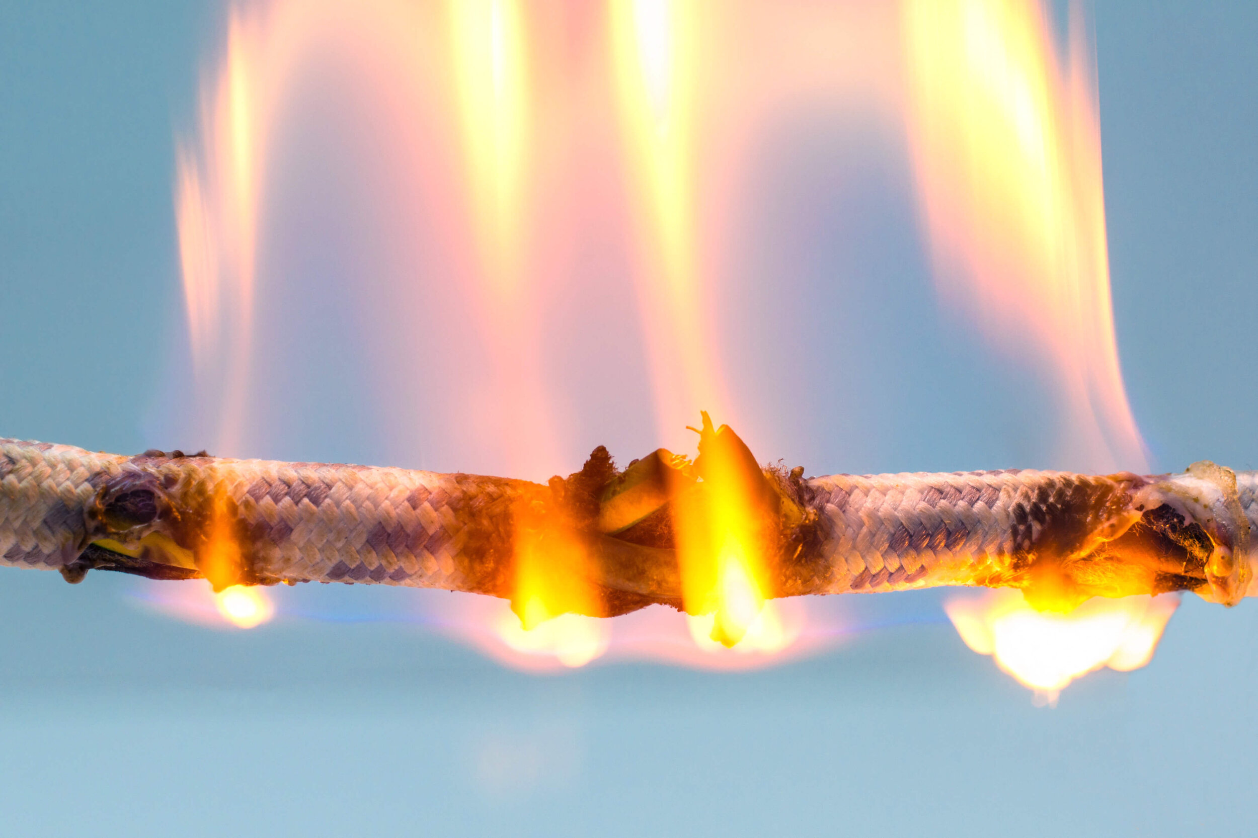 Das Bild zeigt ein Kabel, was brennt. Es sind Flammen zu sehen.