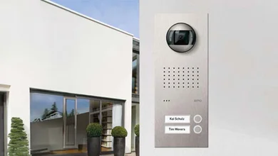 Blick auf das Türstationenmodell Acero von Ritto und im Hintergrund ein modernes weißes Gebäude.