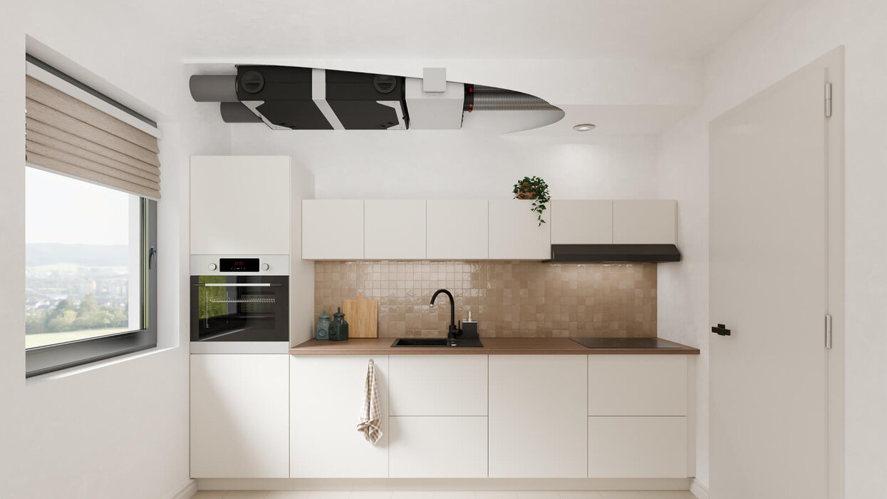 Das Bild zeigt eine moderne, helle Küche. An der Decke ist ein kompaktes Lüftungsgerät unauffällig in eine abgehängte Deckenverkleidung integriert.
