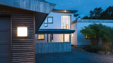 Blick auf ein Haus in der Dämmerung mit Beleuchtung.