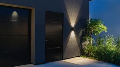 Hausfassade mit Beleuchtung in der Dämmerung.