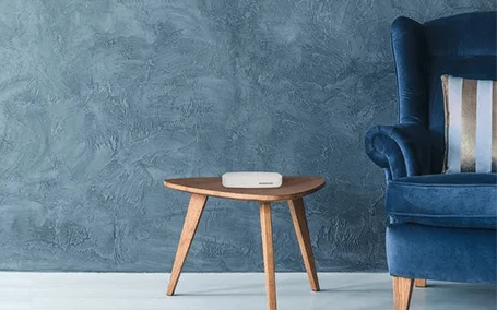 Nierentisch und rechts daneben Anschnitt eines blauen Sofas.