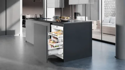 Unterbau Kühlschrank zum Herausziehen von Liebherr integrierte in einer schwarzen Kücheninsel. 