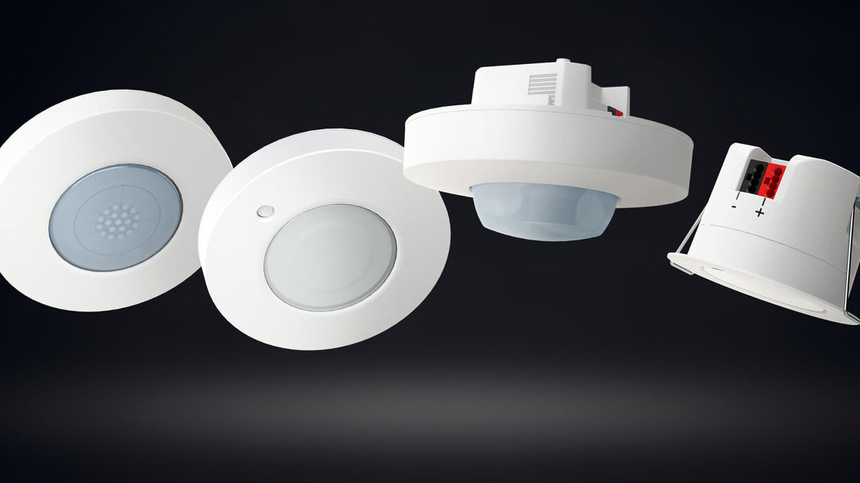 Das Bild zeigt verschiedene Ausführungen des Präsenzmelders der Serie BasicLINE vor dunklem Hintergrund.