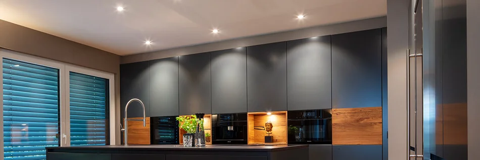 Das Bild zeigt eine moderne Küche mit beleuchteten Schranknischen.