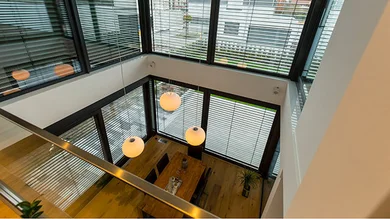 Blick von oben auf ein modernen Wohn/arbeitsraum mit verschiedenen Beleuchtungselementen von Rademacher. 