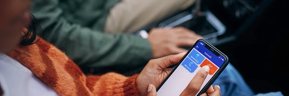 Das Bild zeigt im Ausschnitt mehrere Personen, die ein Smartphone in der Hand halten.