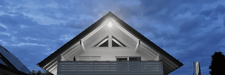 Hausdach von vorne mit Blick auf den Balkon leicht von unten und in der Dämmerung.