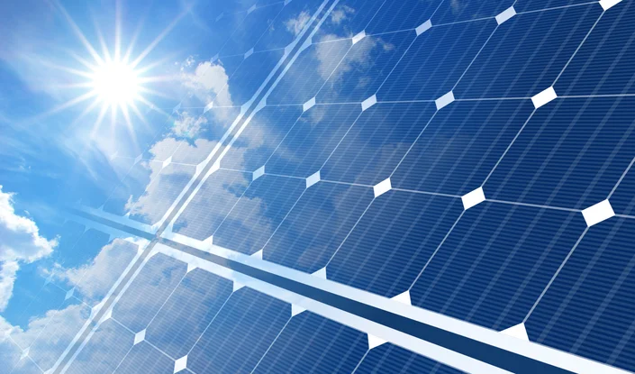 Das Bild zeigt in Großaufnahme eine Photovoltaikanlage vor blauem Himmel.