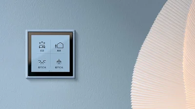 Quadratische Display für das Smart Home an einer grauen Wand im Vordergrund.